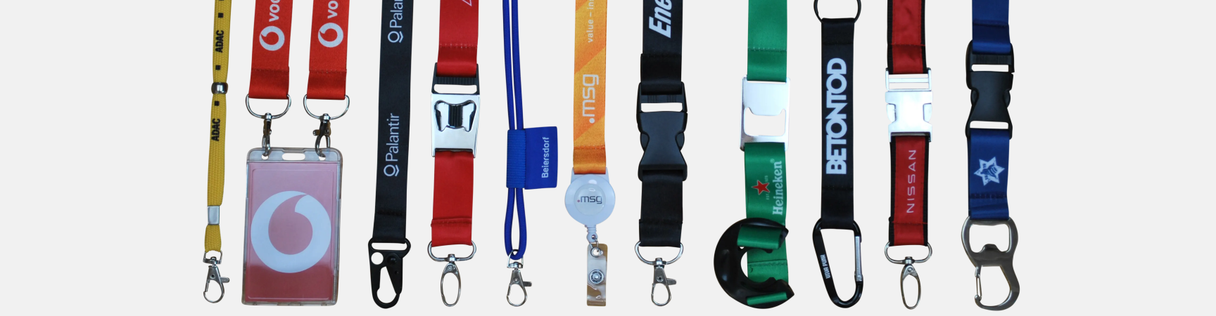 Eine Reihe von verschiedenen Lanyards in unterschiedlichen Farben und Designs, einige mit ID-Haltern.