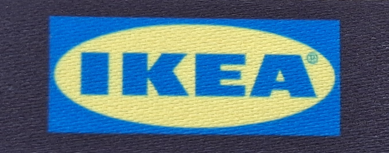 Logo von IKEA, gelb-blau mit dem Schriftzug "IKEA" in großen Buchstaben auf strukturiertem Hintergrund.
